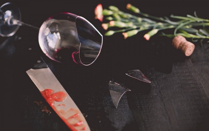 Broken wine glass with knife and flowers