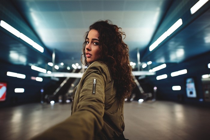 Woman with curly hair in a bomber jacket