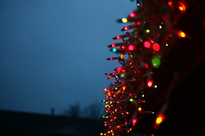 Close-up of colorful Christmas lights against a dark blue sky
