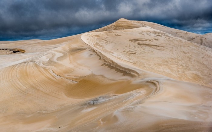 Sand dunes under a stormy sky