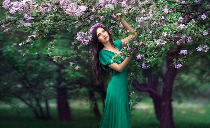 Woman in green dress with flowers in a garden