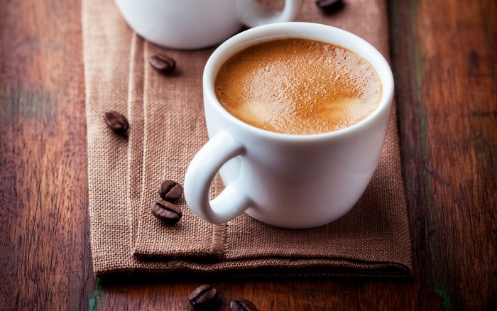 Espresso coffee cup with beans on a burlap cloth