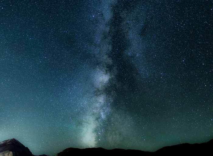 Milky Way galaxy over dark mountains at night