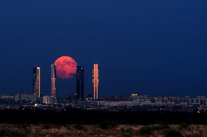 Red Moon over Madrid Skyline with Skyscrapers