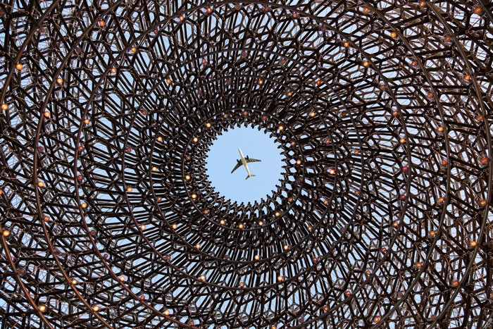 Airplane flying through a circular metal structure