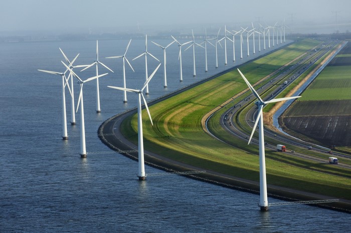 Wind farm with turbines in water and highway