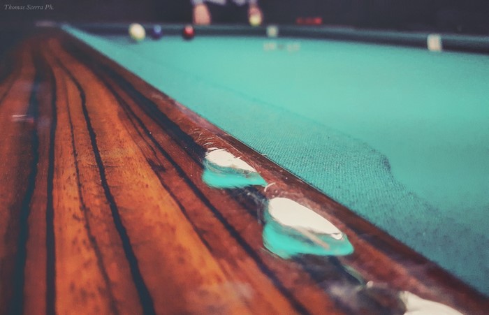 Close-up of a billiard table with balls in the background