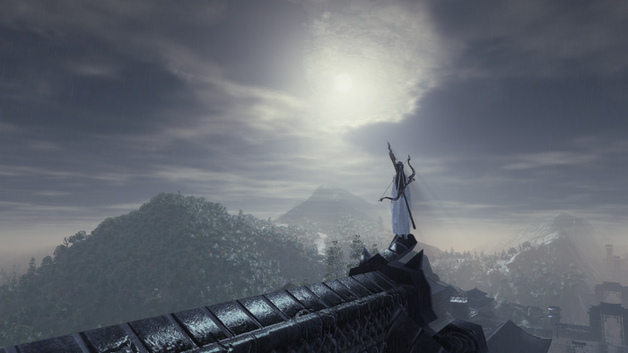Archer statue on a rooftop overlooking mountains