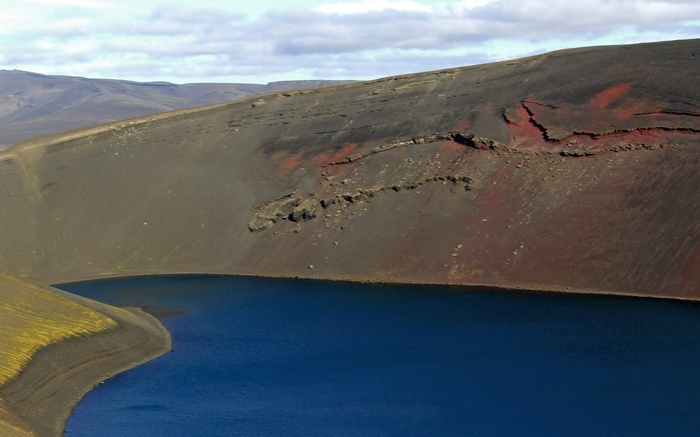 Volcanic Crater Lake with Red and Black Slopes