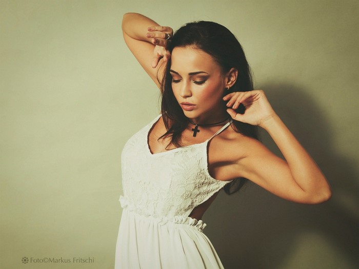 Woman in white dress with cross necklace