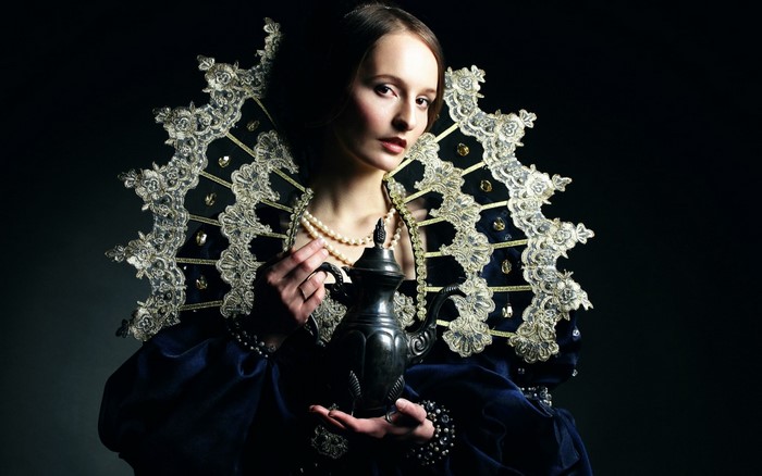 Woman in historical costume holding a teapot