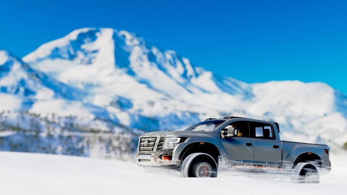 Nissan Titan Warrior driving in snow with mountains