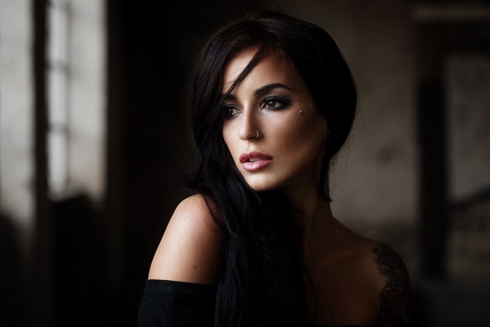 Woman with dark hair and makeup looking away