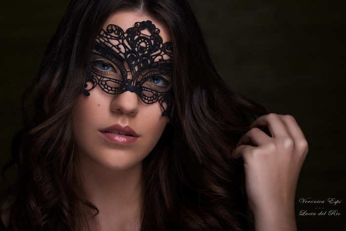 Woman wearing a black lace mask and blue eyes