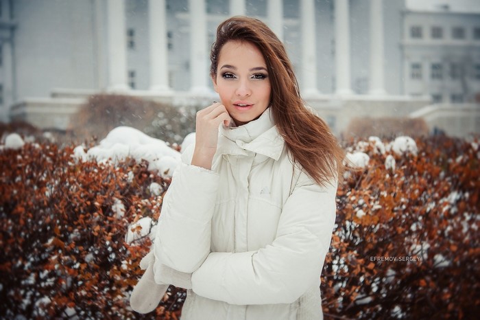 Young Woman in Winter Outfit with Snow Background