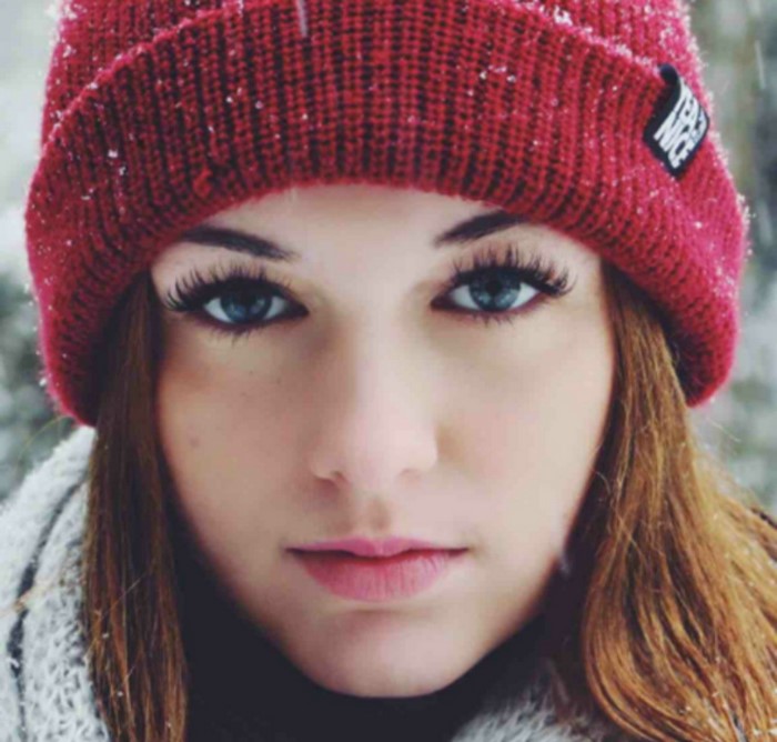 Woman wearing a red beanie in the snow