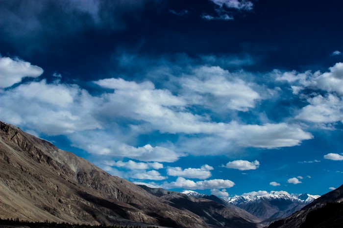 Mountain range under a cloudy blue sky