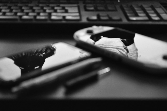 Monochrome close-up of smartphones and keyboard