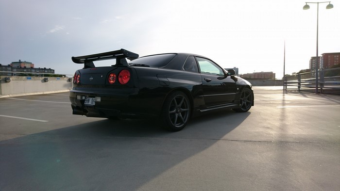 Black Nissan Skyline GT-R R34 parked on rooftop