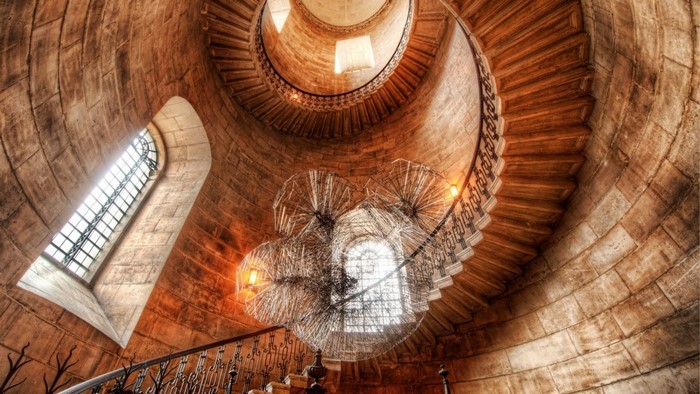 Spiral staircase in a stone tower with chandeliers