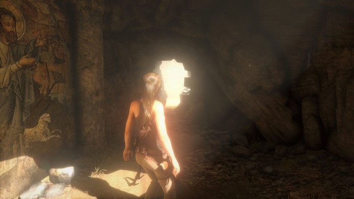 Lara Croft from Tomb Raider in a cave with ancient art