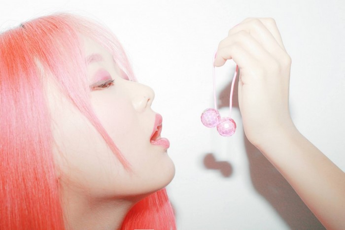 Woman with pink hair holding pink cherry toy