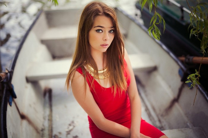Woman in red dress sitting in a boat