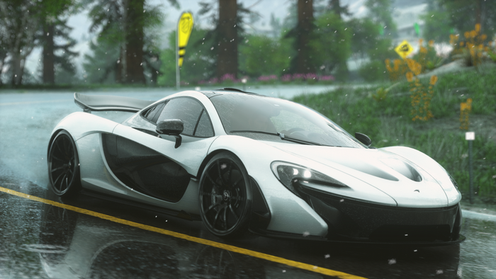 White McLaren P1 driving on a wet road