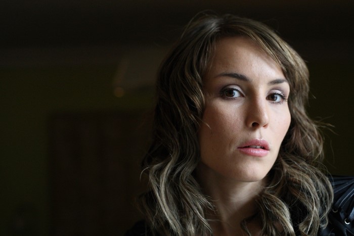 Portrait of Noomi Rapace with long brown hair