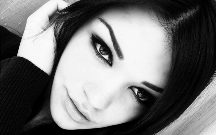 Monochrome portrait of a woman with black hair and dramatic makeup