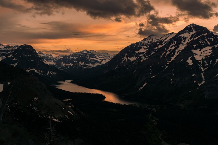 Sunset over a mountain lake with snow-capped peaks