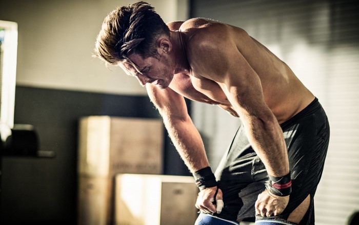Man in gym catching his breath after workout