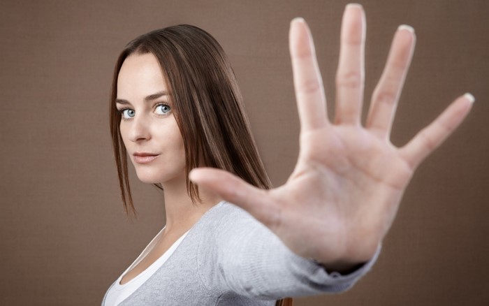Woman holding hand up in front of face