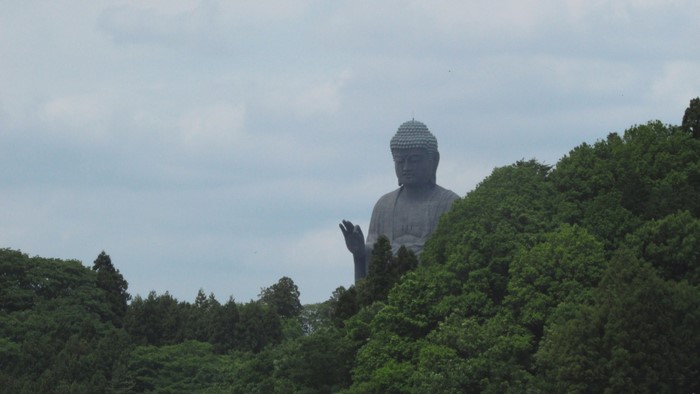 Giant Buddha statue behind green trees