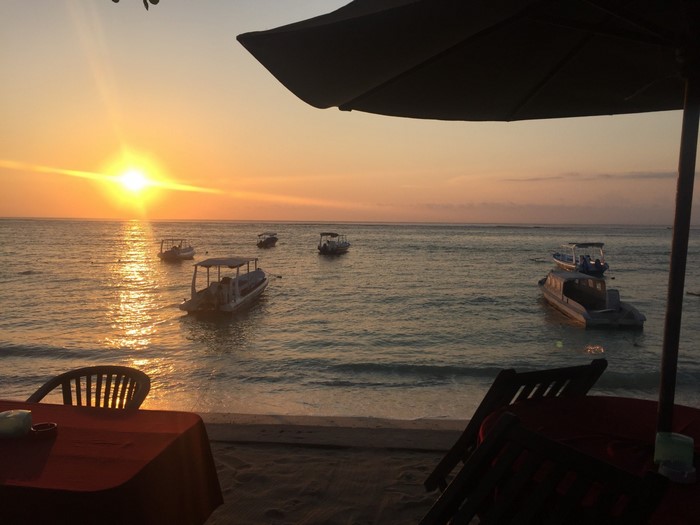 Boats on the sea at sunset with beach tables