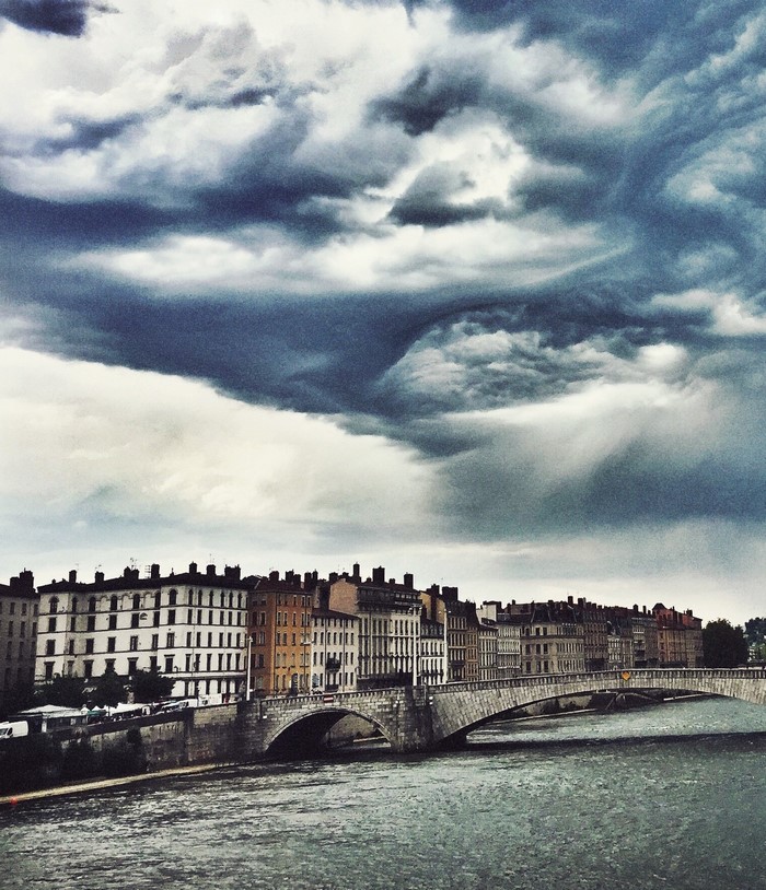 Bridge over river in Lyon with dramatic clouds