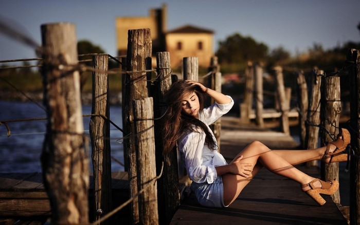 Woman sitting on a wooden pier