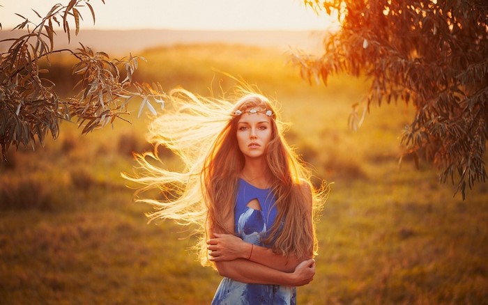Woman with long hair and flower crown at sunset