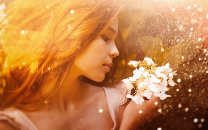 Young woman with auburn hair holding white flowers