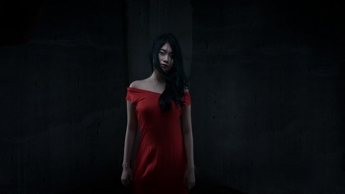 Woman in red dress in dark setting