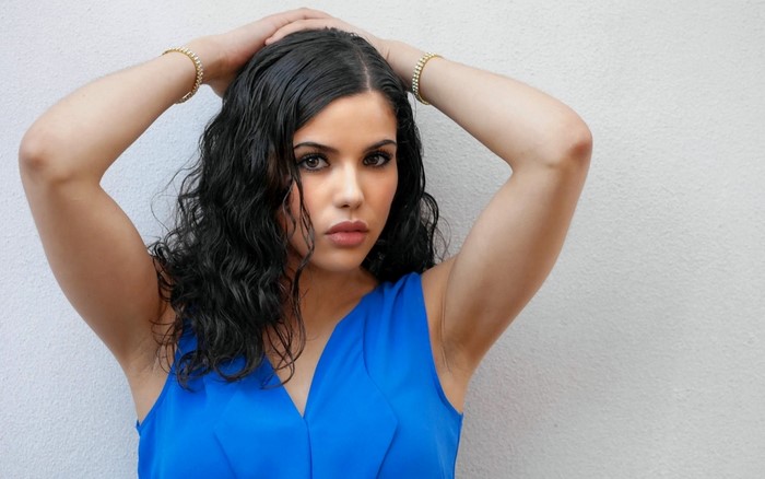 Woman with black curly hair in a blue dress