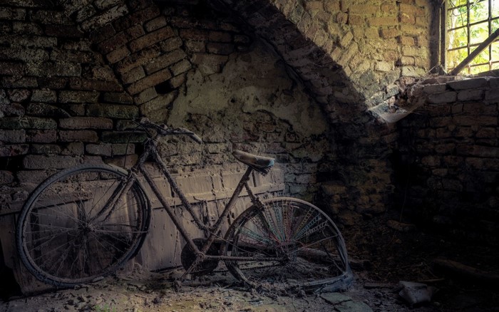 Abandoned rusty bicycle in a brick ruin