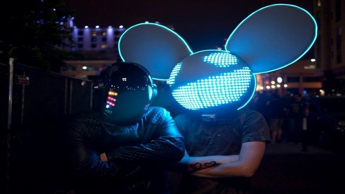 Two DJs in illuminated helmets at night