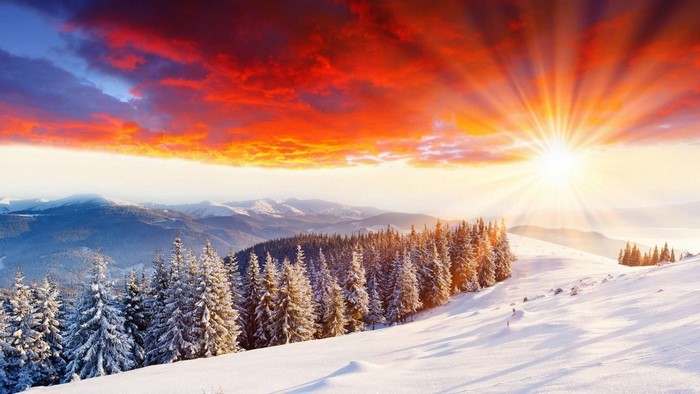Snowy mountains at sunrise with vibrant clouds