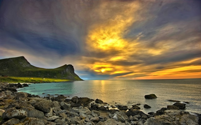Rocky coast with mountains and sunset over the sea
