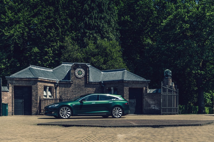 Green Tesla Model S Shooting Brake near brick building