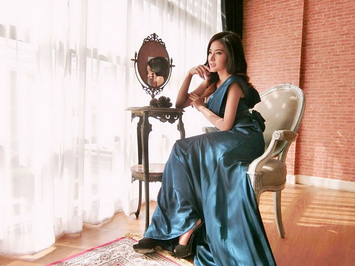 Woman in a blue dress sitting in a chair