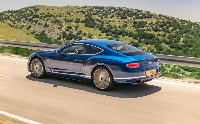 Blue Bentley Continental GT driving on a road