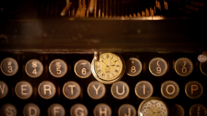Vintage typewriter with pocket watch on keys