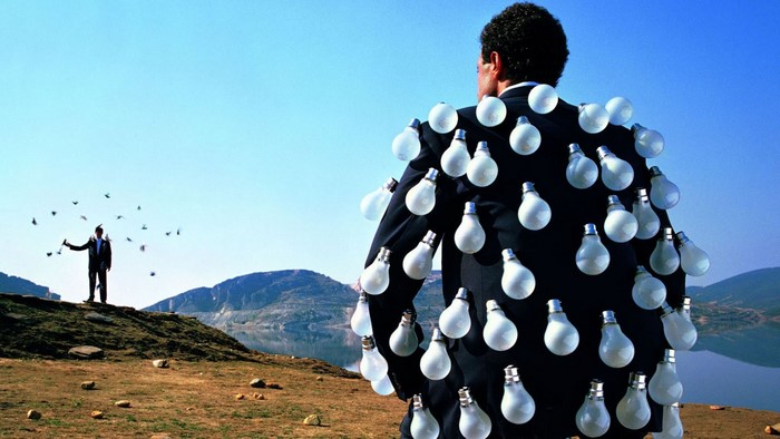 Man with lightbulbs on suit and man releasing birds
